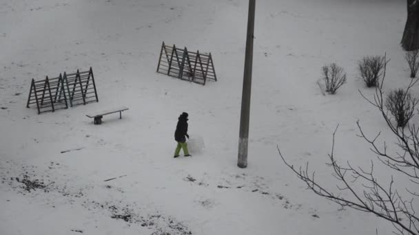 Jongeman Rolt Een Bal Sneeuw Voor Een Sneeuwpop — Stockvideo