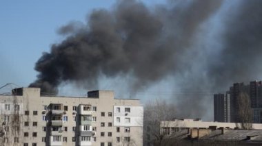 Savaş sırasında şehirde bir roket ya da bomba patlamasından siyah duman çıkar.
