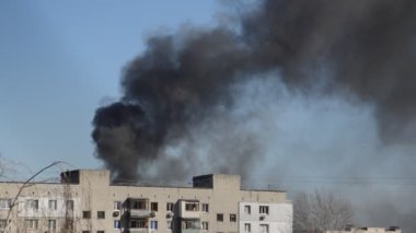 Savaş sırasında şehirde bir roket ya da bomba patlamasından siyah duman çıkar.