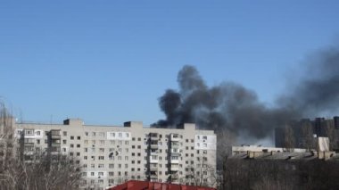 Savaş sırasında şehirde bir roket ya da bomba patlamasından siyah duman çıkar.
