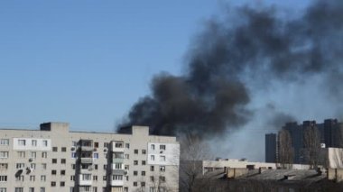 Savaş sırasında şehirde bir roket ya da bomba patlamasından siyah duman çıkar.