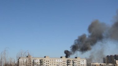 Savaş sırasında şehirde bir roket ya da bomba patlamasından siyah duman çıkar.