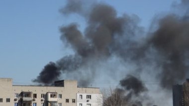 Savaş sırasında şehirde bir roket ya da bomba patlamasından siyah duman çıkar.