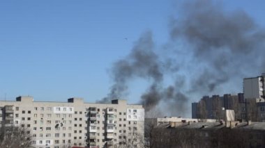 Savaş sırasında şehirde bir roket ya da bomba patlamasından siyah duman çıkar.