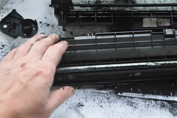 Charging the laser printer cartridge with toner the powder