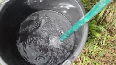 Kuyudan plastik kovalara su dökülüyor.