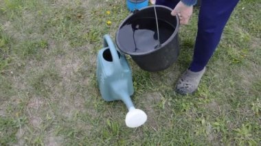 Sebze bahçesini elle sulamak.