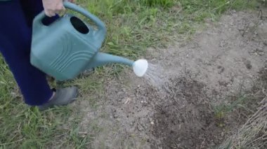 Sebze bahçesini elle sulamak.