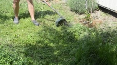 Bahçedeki çimleri biçen bir kadın el budayıcı ile