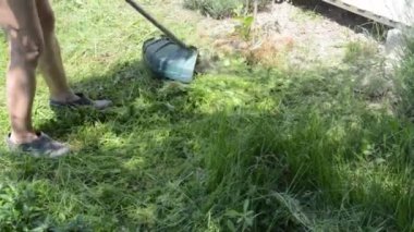 Bahçedeki çimleri biçen bir kadın el budayıcı ile