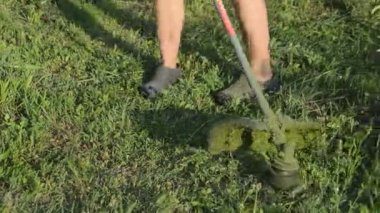 Bahçedeki çimleri biçen bir kadın el budayıcı ile