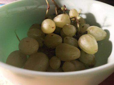 Green washed grapes lie in a the  bowl