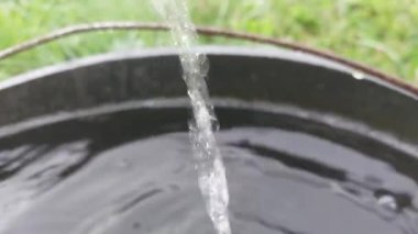 Yağmur suyu bir kovaya damlıyor.