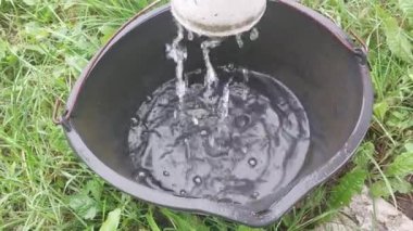 Yağmur suyu bir kovaya damlıyor.