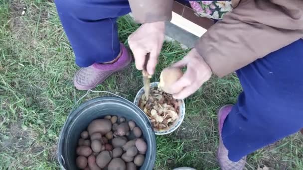 Mujer Pelando Patatas Calle — Vídeos de Stock