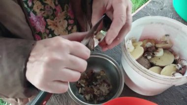 Yemek pişirmek için orman mantarlarını temizliyorum.