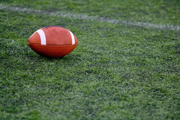 Rugby ball at green grass american foodball — Stock Photo, Image