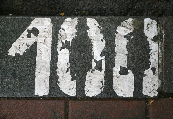 Número de estacionamento pintado em branco no asfalto 100 — Fotografia de Stock