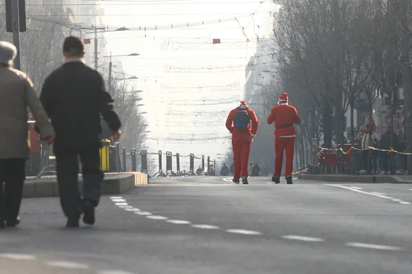 Люди в костюмах Санта-Клауса принимают участие в гонке — стоковое фото