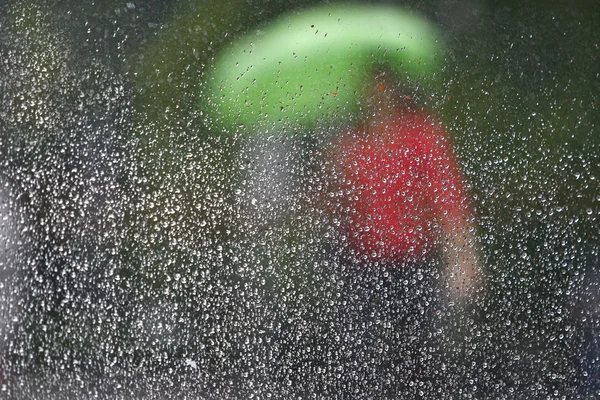 Pioggia su finestra e la gente in una scena stradale — Foto Stock