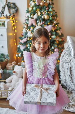 Noel ailesi. Noel ağacının arka planındaki kız çocuğu. Yeni yıl kutlaması. Mutlu Noeller ve mutlu yıllar.