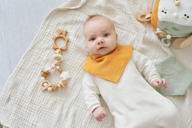 Yeni doğmuş bebek yalan söyler ve eğitici oyuncaklarla oynar. Anneliğin ve babalığın kutlu olsun. Doğum hastanesi ve kliniği. Babalar günü. Erken çocukluk gelişimi.