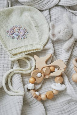 Hobiler ve el sanatları. El yapımı nakışla örülmüş bir bere. Tahta oyuncaklar, çıngıraklar, ipler, meme ucu tutacağı. Bebek gelişimi, iyi motor beceriler. Çocuklar ve yeni doğan ürünler ve aksesuarlar