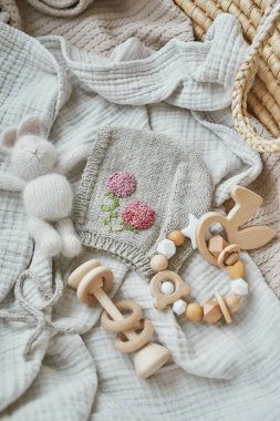 Hobiler ve el sanatları. El yapımı nakışla örülmüş bir bere. Tahta oyuncaklar, çıngıraklar, ipler, meme ucu tutacağı. Bebek gelişimi, iyi motor beceriler. Çocuklar ve yeni doğan ürünler ve aksesuarlar