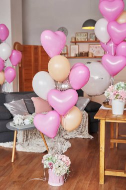 Sevgililer Günü. Uluslararası Mutluluk Günü. Stüdyo daire, çatı katı tarzı. Tatil dekoru. Pembe balonlar ve çiçekler