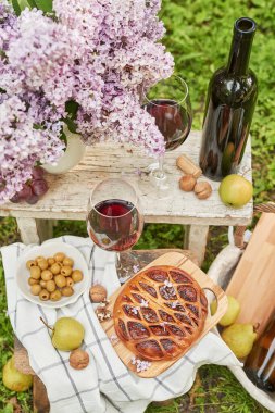 Bahçede yaz pikniği. Şarap, turta, meyve ve çiçekler. Durgun hayat. Paskalya yemeği ve masa..