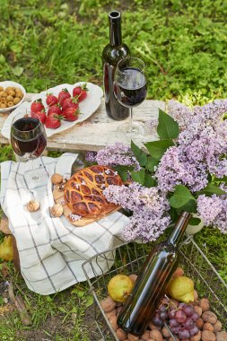 Bahçede yaz pikniği. Şarap, turta, meyve ve çiçekler. Durgun hayat. Paskalya yemeği ve masa..