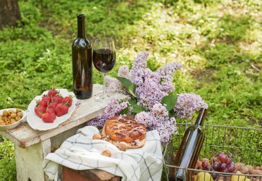 Bahçede yaz pikniği. Şarap, turta, meyve ve çiçekler. Durgun hayat. Paskalya yemeği ve masa..