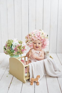 Çiçek şapkalı bebek. Anneler Günü ve Paskalya kartı. Çocuk Koruma Günü. Dünya Mutluluk Günü. Gülümseyen çocuk.