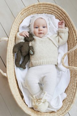 Hasır beşikteki bebek tahta oyuncakla. Anneler Günü. Çocuk Koruma Günü. Neşeli çocuk, mutlu çocukluk.