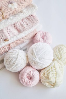 Yığınla örgü elbise, iplik yumakları, örgü şişleri, örmek için aksesuarlar. Bebek kıyafetleri. İğne, hobi, örgü, el işi.