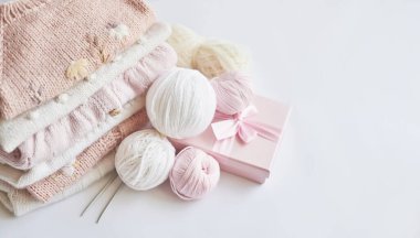 Yığınla örgü elbise, iplik yumakları, örgü şişleri, örmek için aksesuarlar. Bebek kıyafetleri. İğne, hobi, örgü, el işi.