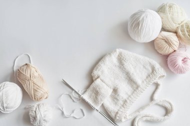 Bebek şapkası örme süreci. İplik derileri, örgü şişleri, örgü için aksesuarlar. El yapımı, hobi.