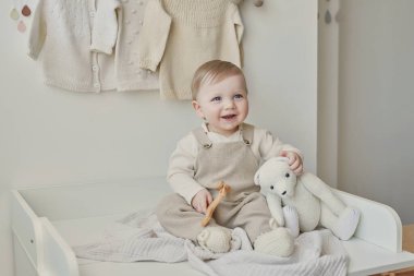 Wonderful baby boy with blue eyes. Child playing with toys in nursery. Early development, kindergarten, nursery, playroom. Children's Day, Mother's Day.