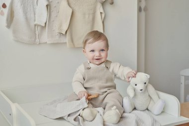 Wonderful baby boy with blue eyes. Child playing with toys in nursery. Early development, kindergarten, nursery, playroom. Children's Day, Mother's Day.