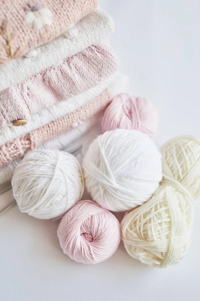 Yığınla örgü elbise, iplik yumakları, örgü şişleri, örmek için aksesuarlar. Bebek kıyafetleri. İğne, hobi, örgü, el işi.