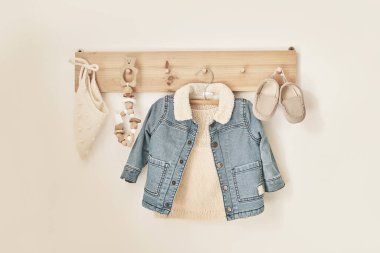 Askıya asılmış çocuk örgüsü. Kot ceket, kazak, şapka, ayakkabı. Çocuk odası, çocuk odası..