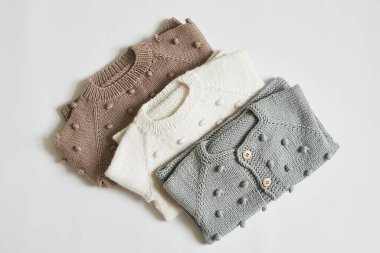 Bir yığın örgü kıyafet. Bebek kıyafetleri. İğne, hobi, örgü, el işi..