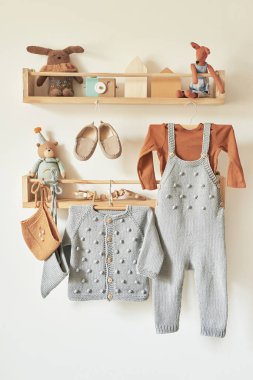 Askıya asılmış çocuk örgüsü. Ceket, kazak, şapka, ayakkabı. Oyuncaklar. Çocuk odası, çocuk odası..