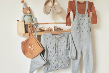 Askıya asılmış çocuk örgüsü. Ceket, kazak, şapka, ayakkabı. Oyuncaklar. Çocuk odası, çocuk odası..