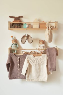 Askıya asılmış çocuk örgüsü. Ceket, kazak, şapka, ayakkabı. Oyuncaklar. Çocuk odası, çocuk odası..