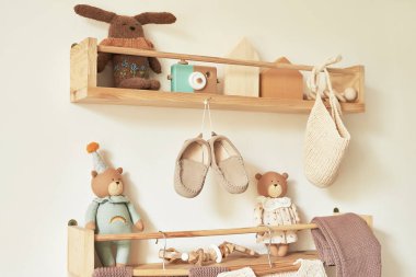 Children's knitted clothes on hanger. Jacket, jumper, hat, shoes. toys. Children's room, nursery.