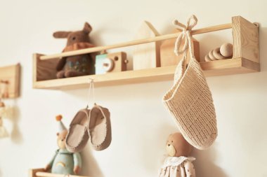 Children's knitted clothes on hanger. Jacket, jumper, hat, shoes. toys. Children's room, nursery.