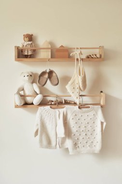 Children's knitted clothes on hanger. Jacket, jumper, hat, shoes. toys. Children's room, nursery.
