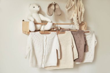 Askıya asılmış çocuk örgüsü. Ceket, kazak, şapka, ayakkabı. Oyuncaklar. Çocuk odası, çocuk odası..
