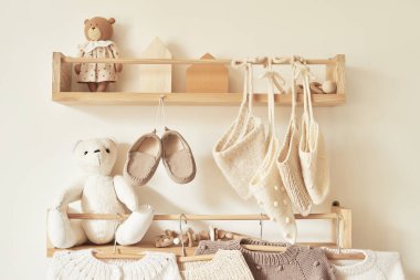 Children's knitted clothes on hanger. Jacket, jumper, hat, shoes. toys. Children's room, nursery.